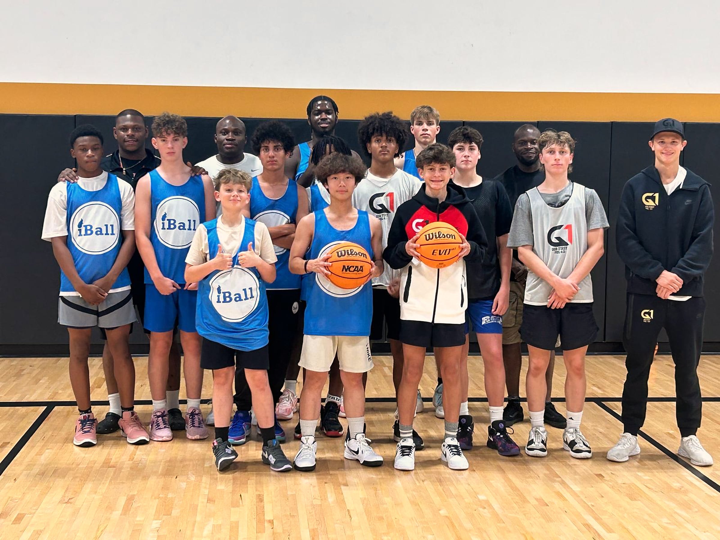 A line of iBall players in blue jerseys standing together on court